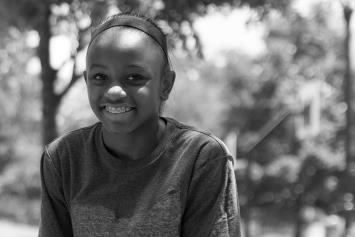 Preteen Girl Sitting Outside and Smiling 