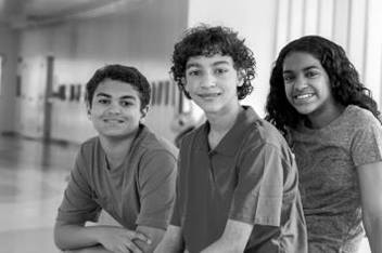 Two Teen Boys and One Teen Girl Sitting in Hallway 