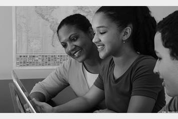 Two kids and their mom looking at a tablet