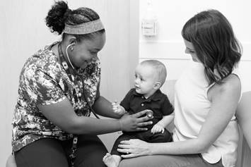 Mom and Baby Interacting With Nurse at Primary Care Visit