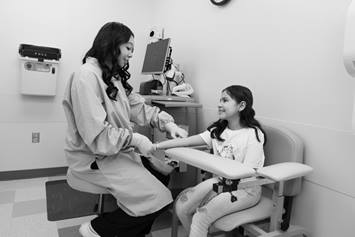 Child being seen by a medical professional in clinic.